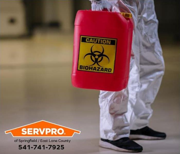 A professional carries a container of biohazardous materials.